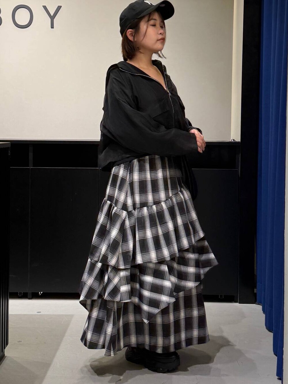 ブラック系のスニーカー、ブラック系のショルダーバッグ、ホワイト系のスカートを着用したレディースの秋コーディネートの3枚目の写真