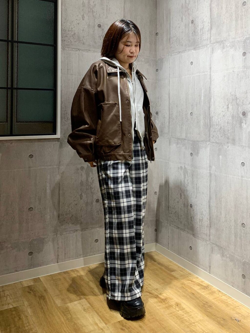 ブラック系のスニーカー、ブラウン系のブルゾン、グレー系のパーカーを着用したレディースの秋コーディネートの2枚目の写真