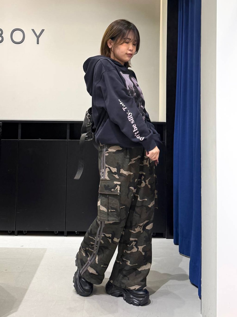 ブラック系のスニーカー、ブラック系のボストンバッグ、グリーン系のスウェットパンツを着用したレディースの冬コーディネートの4枚目の写真