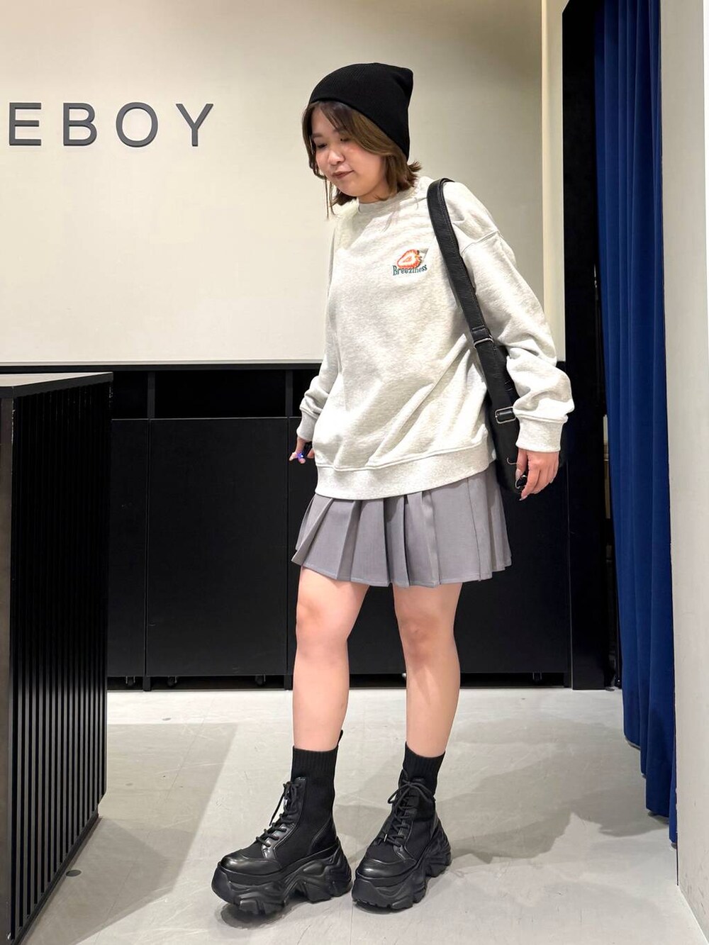 ブラック系のブーツ、グレー系のスウェット、ブラック系のショルダーバッグを着用したレディースの冬コーディネートの7枚目の写真