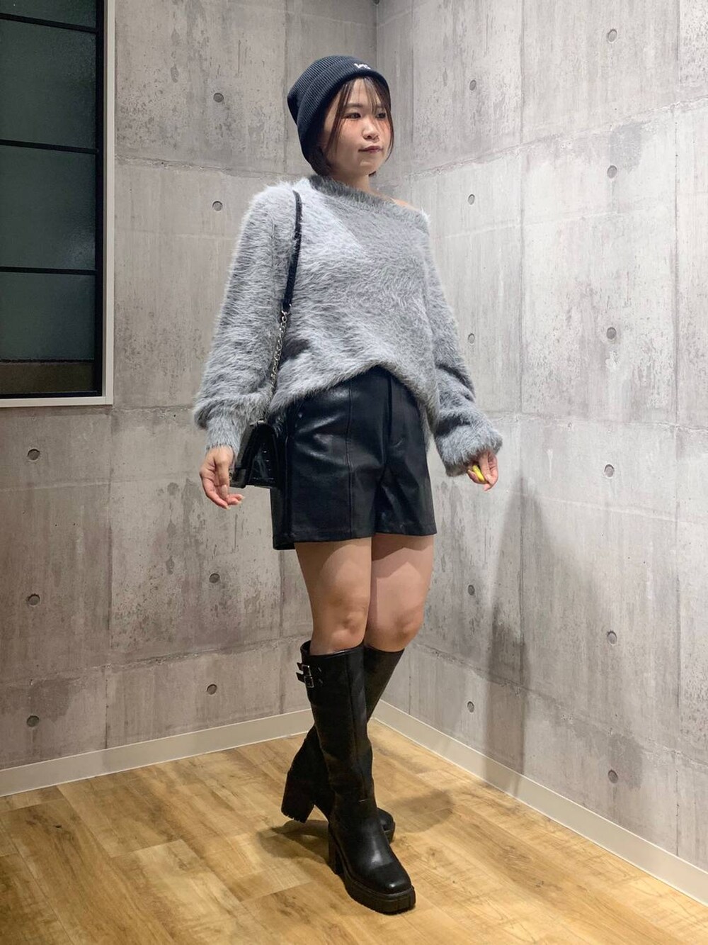 ブラック系のブーツ、ブラック系のハンドバッグ、グレー系のニット/セーターを着用したレディースの秋コーディネートの3枚目の写真