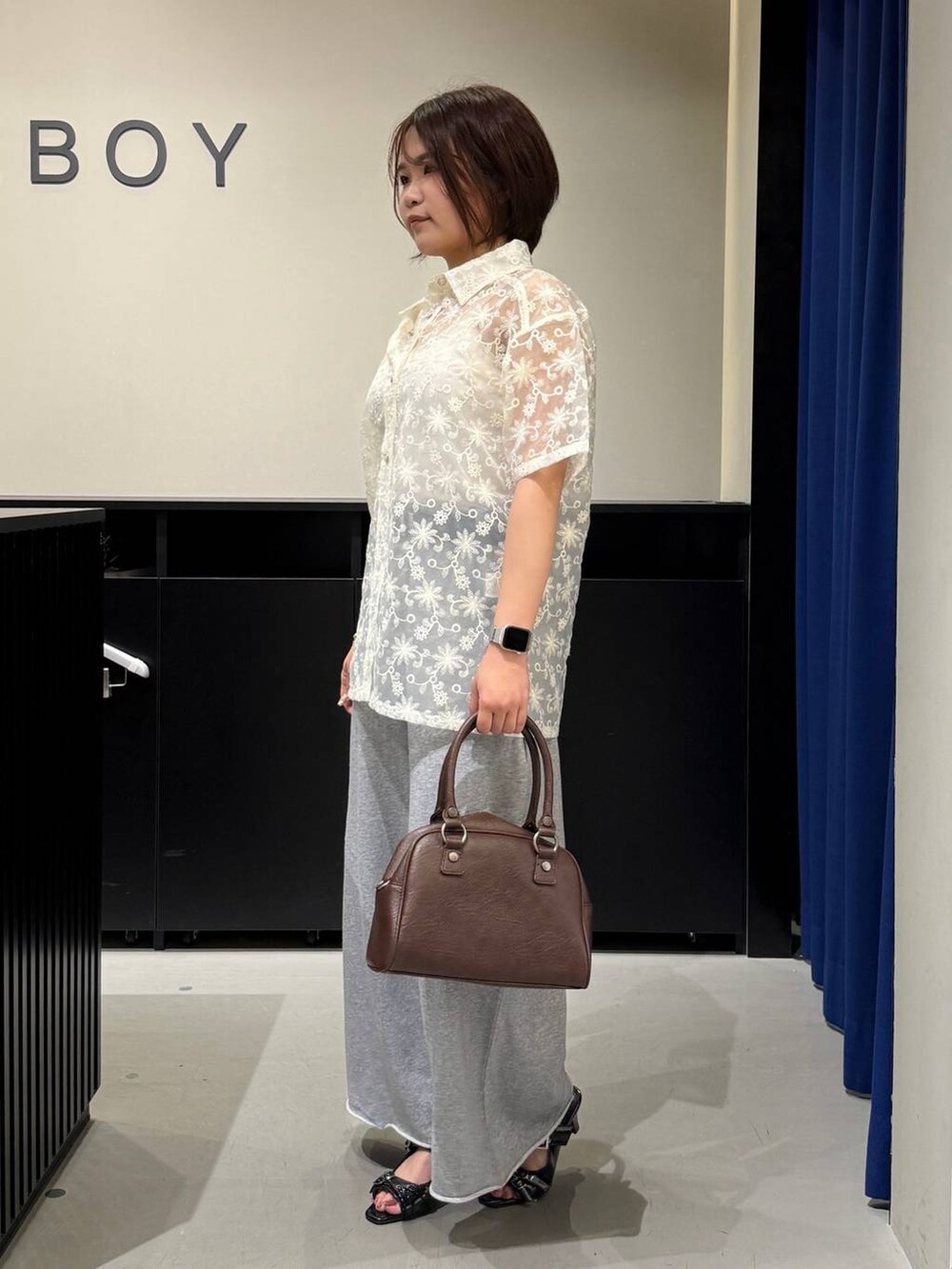 ホワイト系のキャミソール、ブラック系のサンダル、ブラウン系のショルダーバッグを着用したレディースの夏コーディネートの5枚目の写真