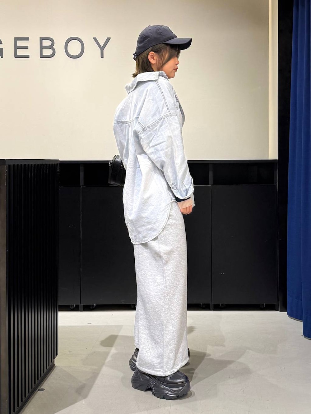 ブラック系のスニーカー、ブラック系のボストンバッグ、ブルー系のシャツ/ブラウスを着用したレディースの冬コーディネートの4枚目の写真