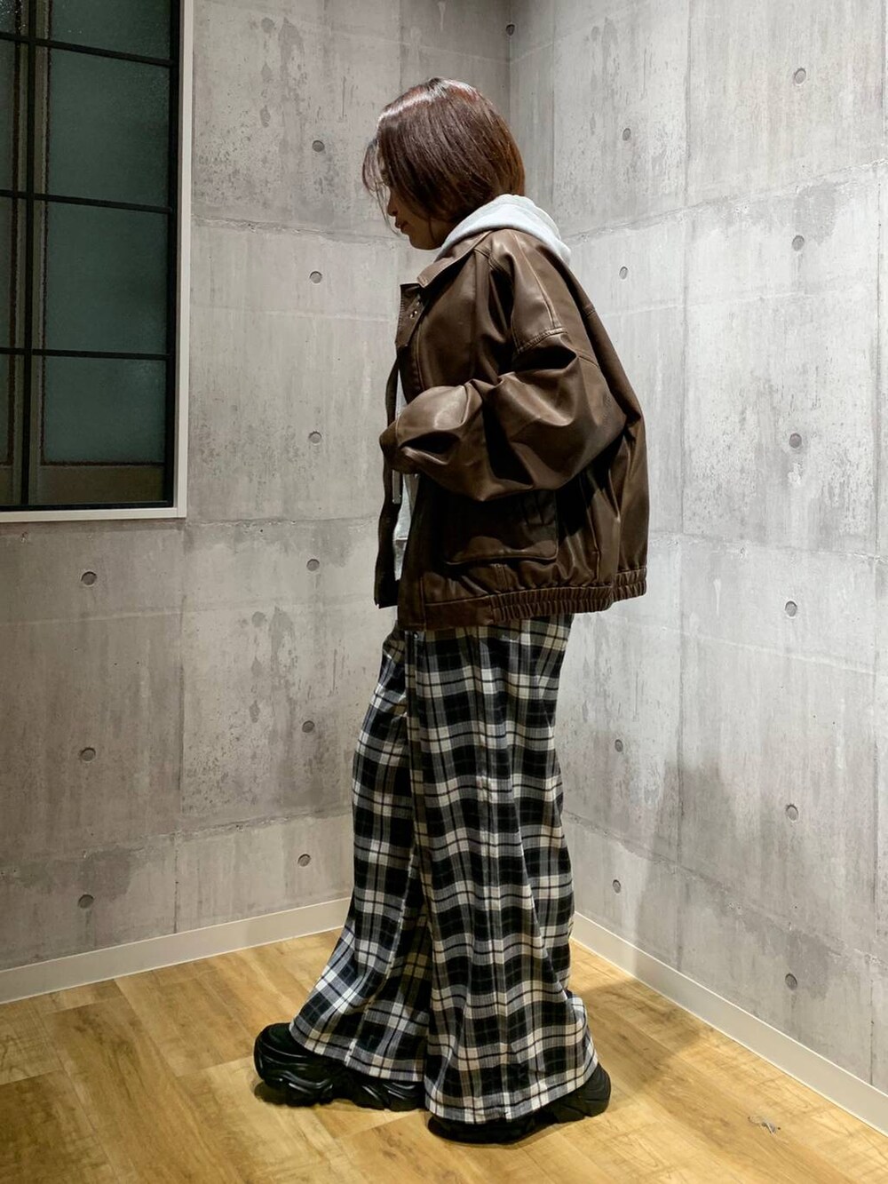 ブラック系のスニーカー、ブラウン系のブルゾン、グレー系のパーカーを着用したレディースの秋コーディネートの6枚目の写真