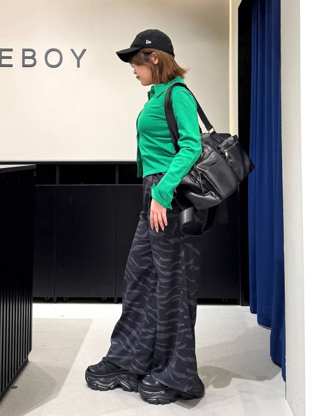 ブラック系のスニーカー、ホワイト系のキャミソール、ブラック系のボストンバッグを着用したレディースの冬コーディネートの6枚目の写真