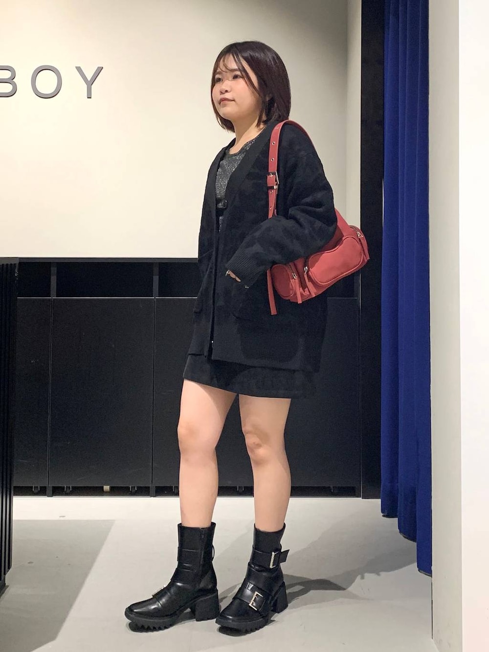 シルバー系のTシャツ/カットソー、ブラック系のスカート、ブラック系のブーツを着用したレディースの秋コーディネートの7枚目の写真