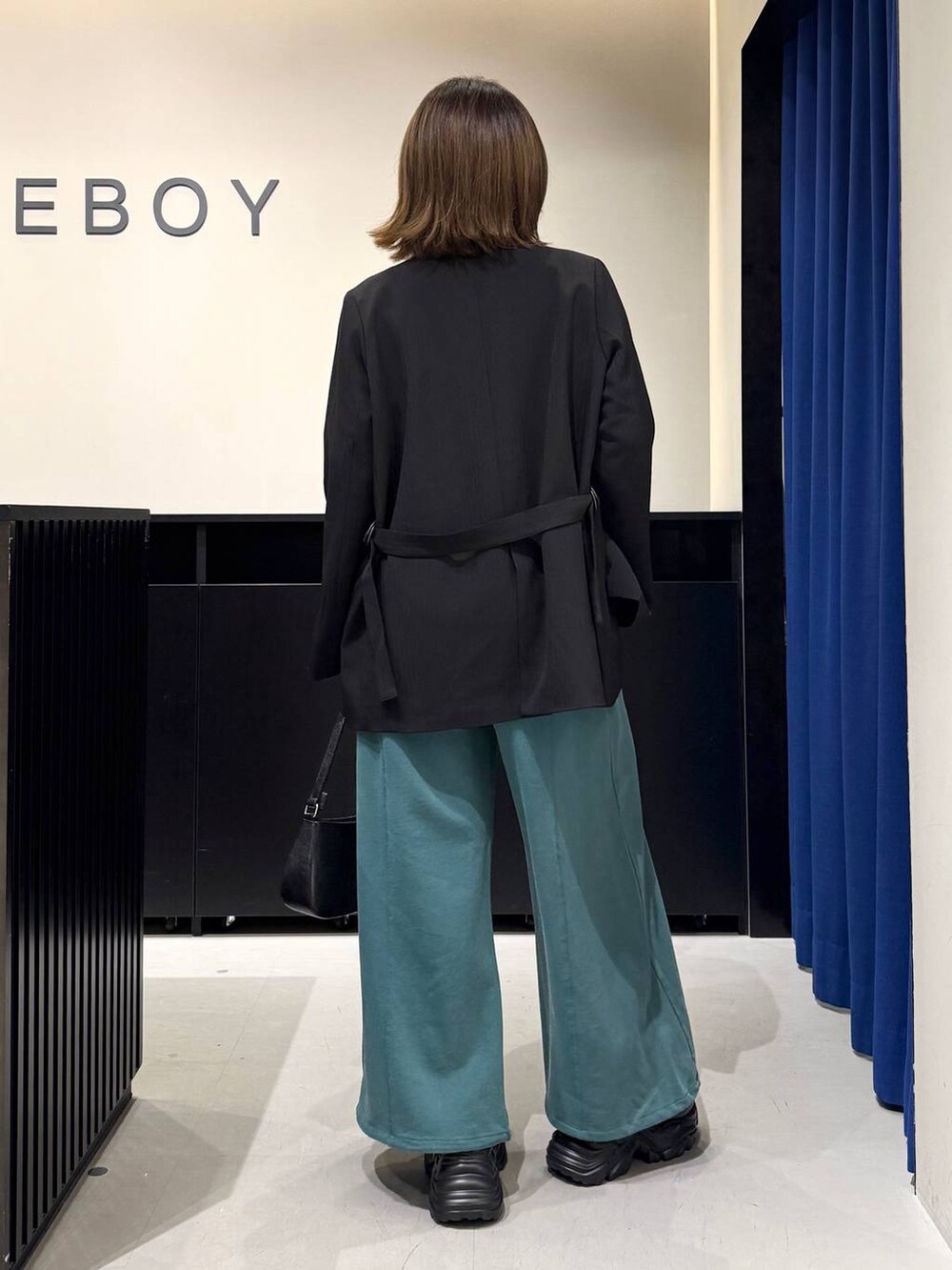 ブラック系のスニーカー、ホワイト系のニット/セーター、ブラック系のテーラードジャケットを着用したレディースの冬コーディネートの5枚目の写真