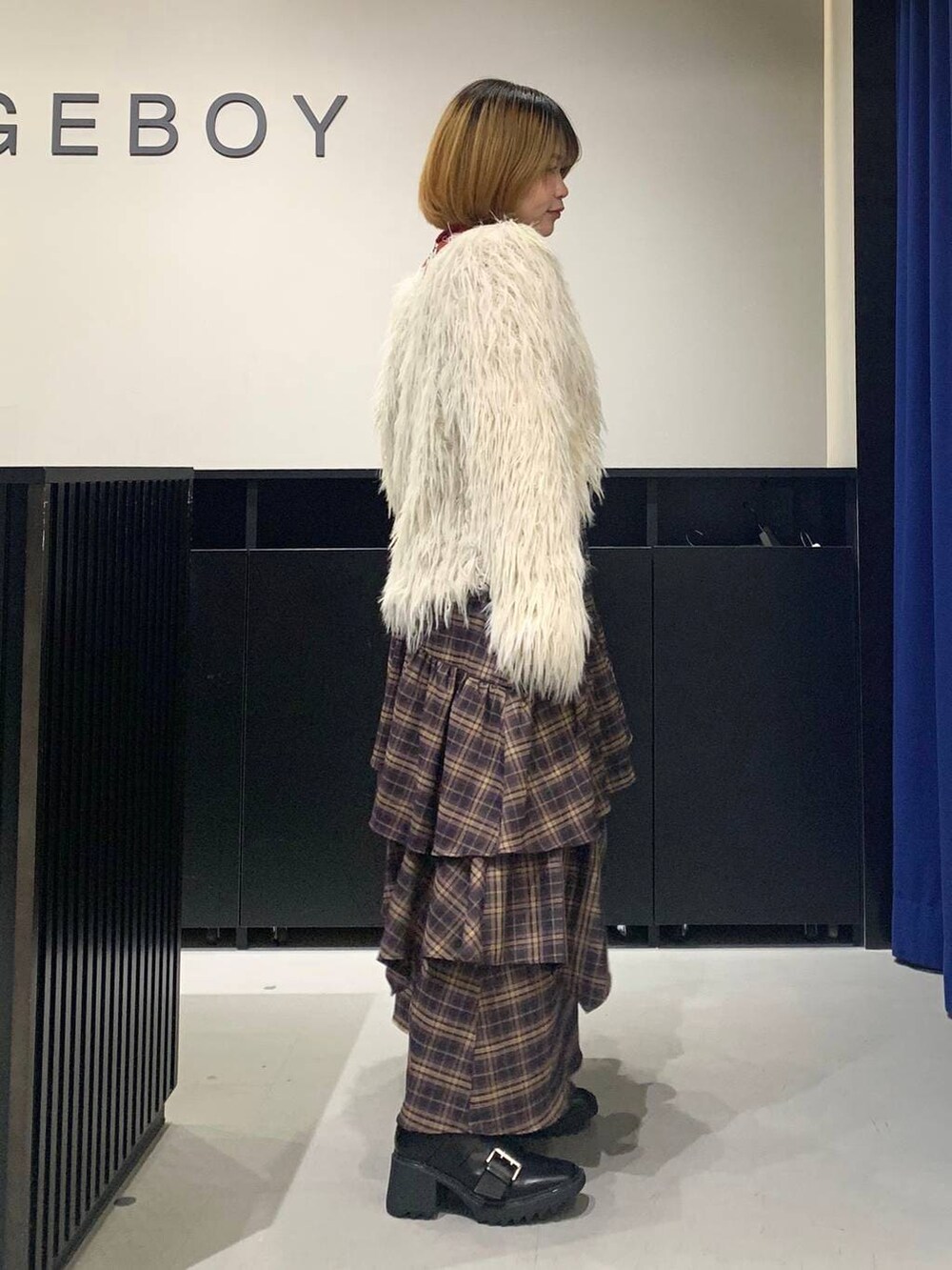 ブラック系のブーツ、ブラウン系のスカート、ブラウン系のショルダーバッグを着用したレディースの冬コーディネートの4枚目の写真