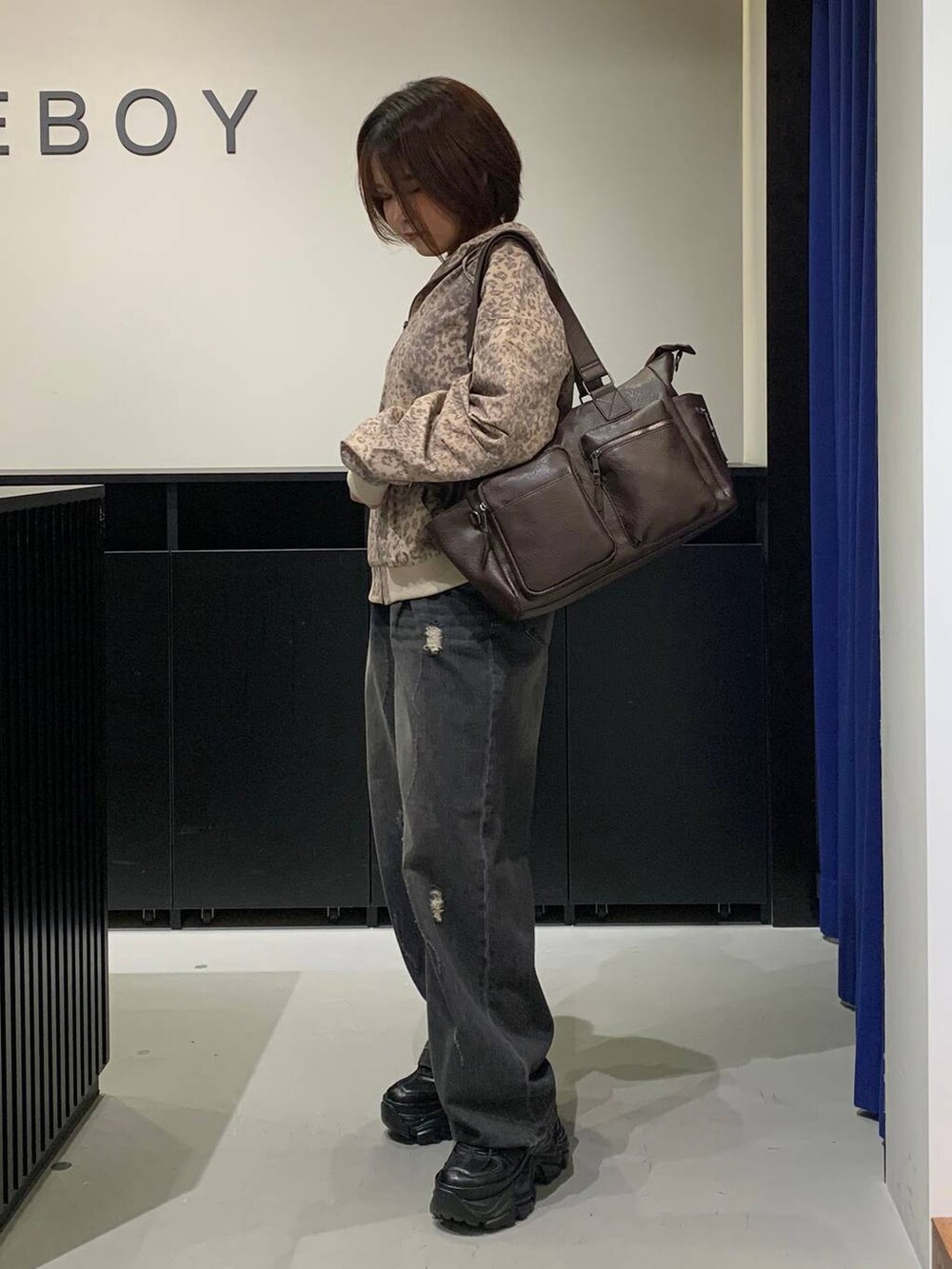 ブラック系のスニーカー、ブラウン系のボストンバッグ、その他のブルゾンを着用したレディースの秋コーディネートの6枚目の写真