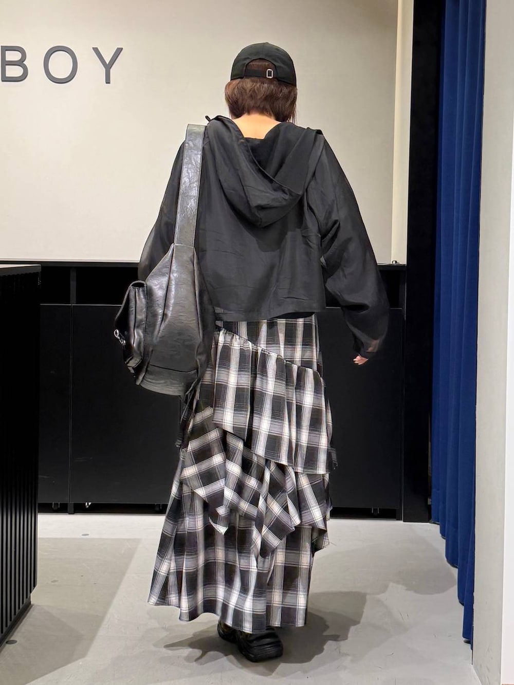 ブラック系のスニーカー、ブラック系のショルダーバッグ、ホワイト系のスカートを着用したレディースの秋コーディネートの5枚目の写真