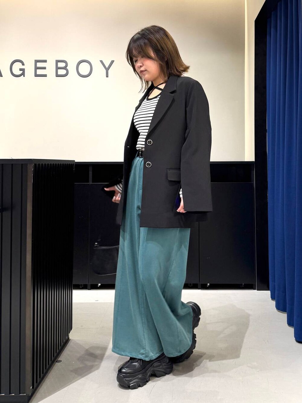 ブラック系のスニーカー、ホワイト系のニット/セーター、ブラック系のテーラードジャケットを着用したレディースの冬コーディネートの7枚目の写真