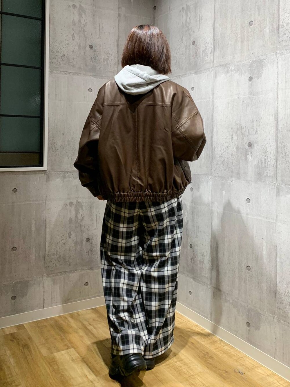 ブラック系のスニーカー、ブラウン系のブルゾン、グレー系のパーカーを着用したレディースの秋コーディネートの5枚目の写真