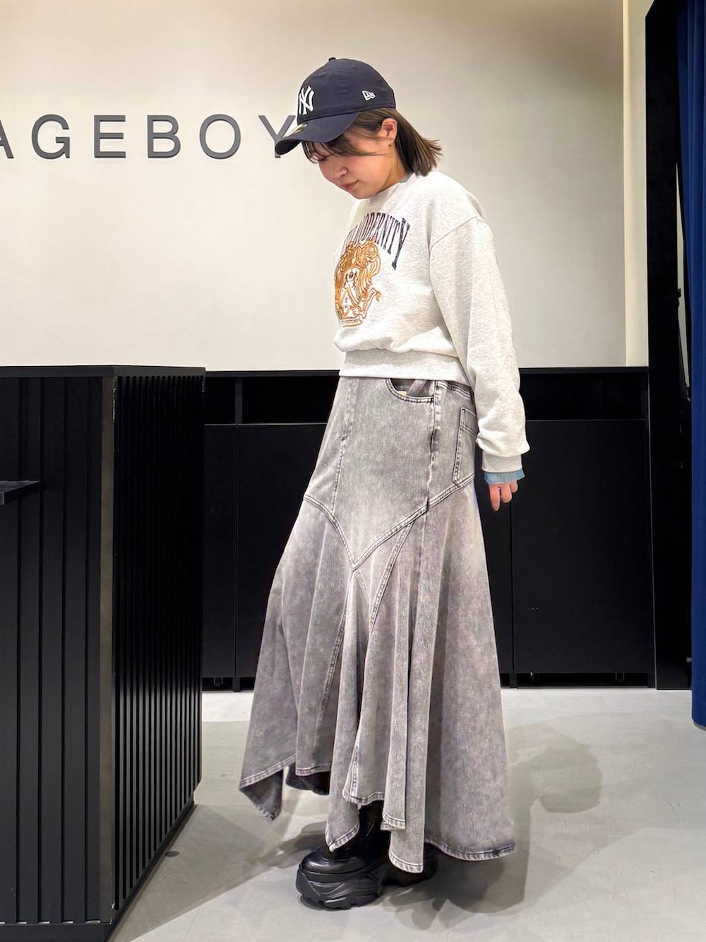 ブラック系のブーツ、イエロー系のボストンバッグ、グレー系のスウェットを着用したレディースの冬コーディネートの6枚目の写真