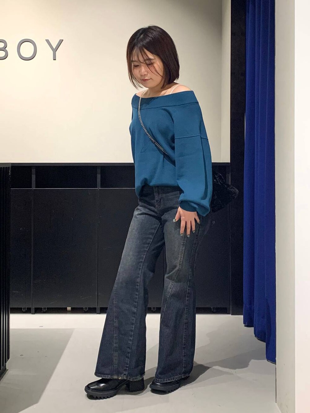 ホワイト系のキャミソール、ブルー系のデニムパンツ、グリーン系のニット/セーターを着用したレディースの秋コーディネートの7枚目の写真