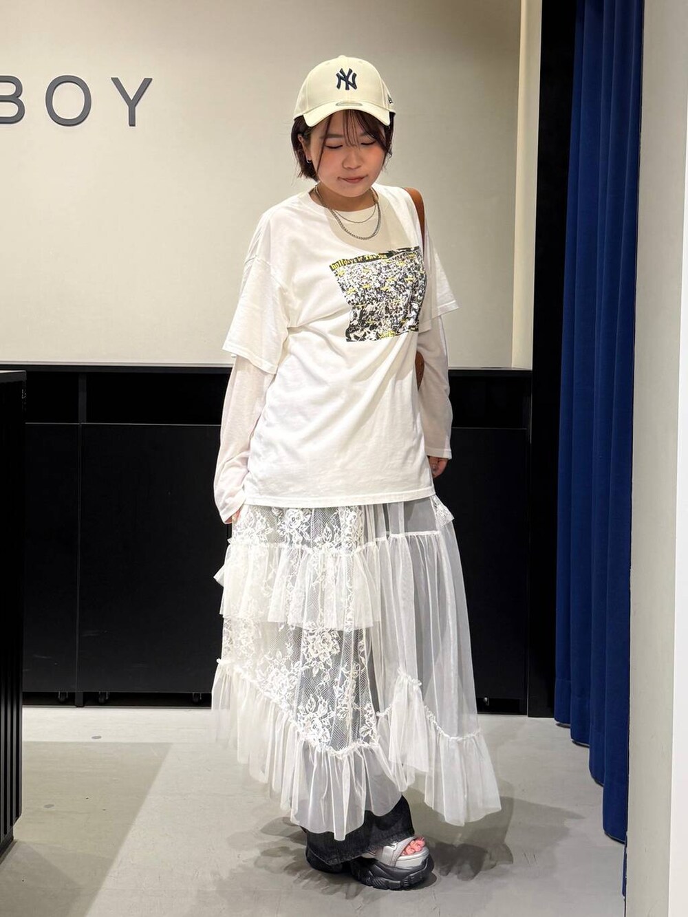 グレー系のサンダル、ブラック系のデニムパンツ、ブラウン系のショルダーバッグを着用したレディースの夏コーディネートの3枚目の写真