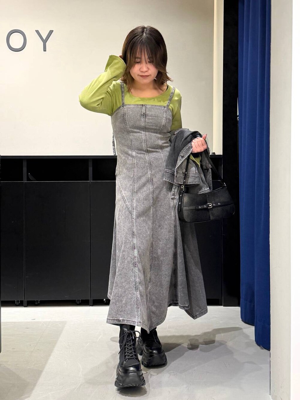 ブラック系のブーツ、ブラック系のハンドバッグ、ブラック系のブルゾンを着用したレディースの冬コーディネートの2枚目の写真