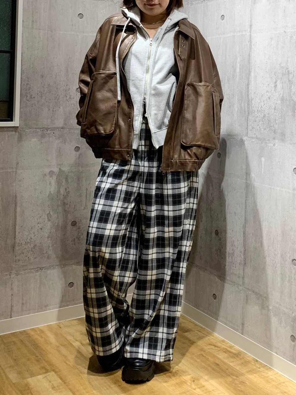 ブラック系のスニーカー、ブラウン系のブルゾン、グレー系のパーカーを着用したレディースの秋コーディネートの3枚目の写真