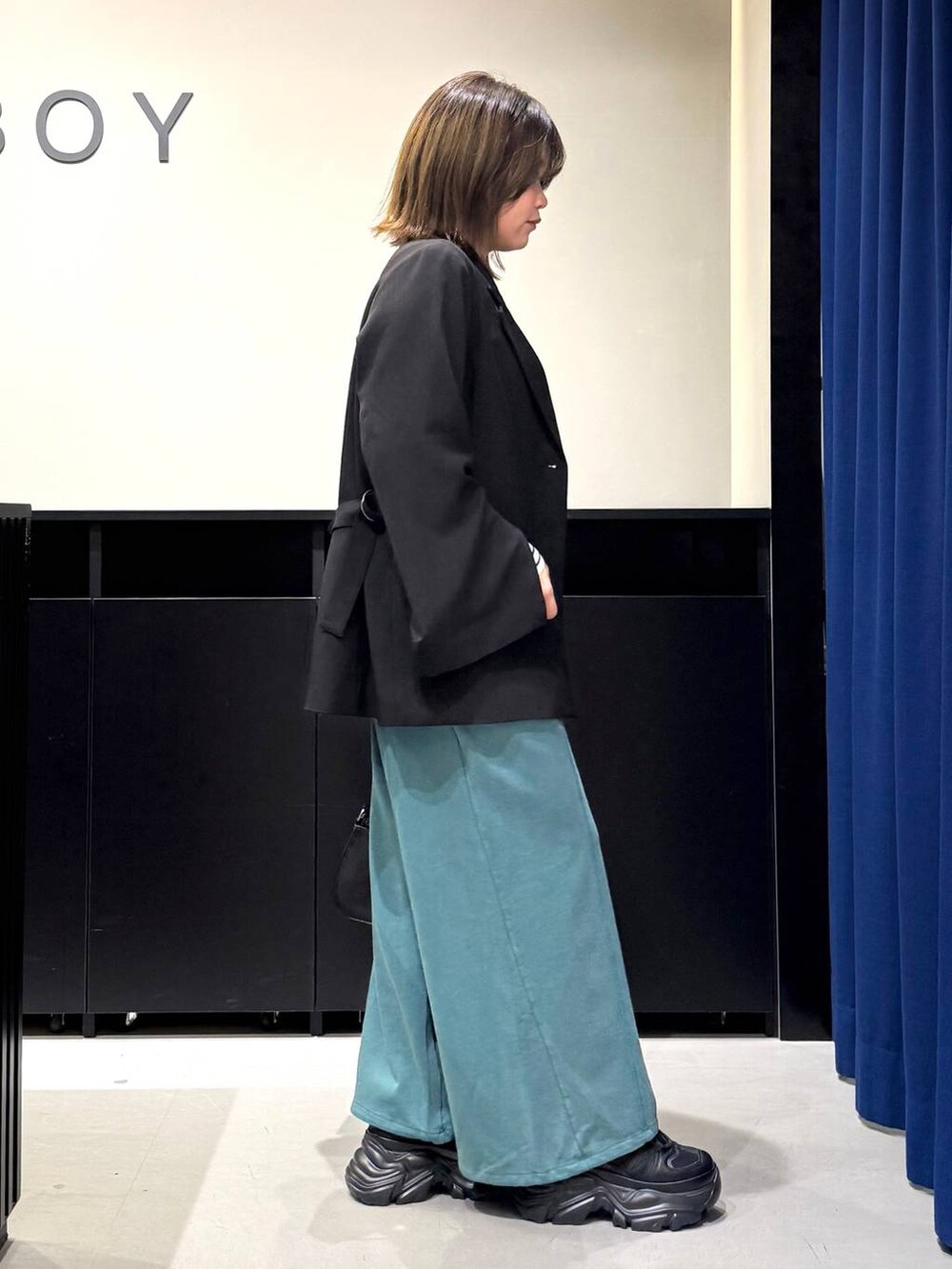 ブラック系のスニーカー、ホワイト系のニット/セーター、ブラック系のテーラードジャケットを着用したレディースの冬コーディネートの4枚目の写真