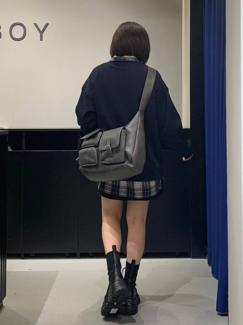 ブラック系のブーツ、グレー系のショルダーバッグ、ブラック系のスカートを着用したレディースの秋コーディネートの5枚目の写真