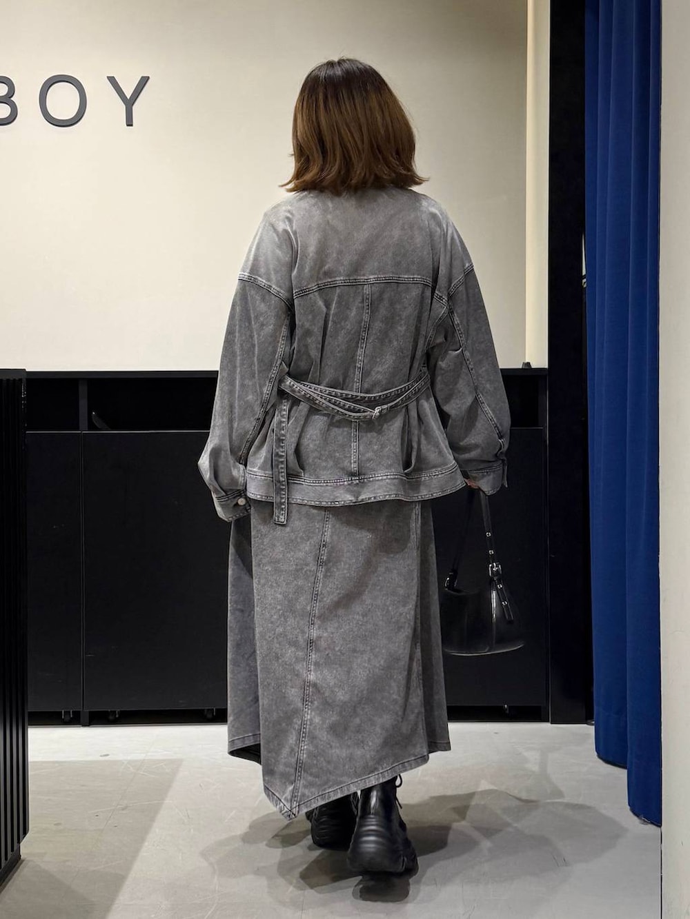 ブラック系のブーツ、ブラック系のハンドバッグ、ブラック系のブルゾンを着用したレディースの冬コーディネートの6枚目の写真