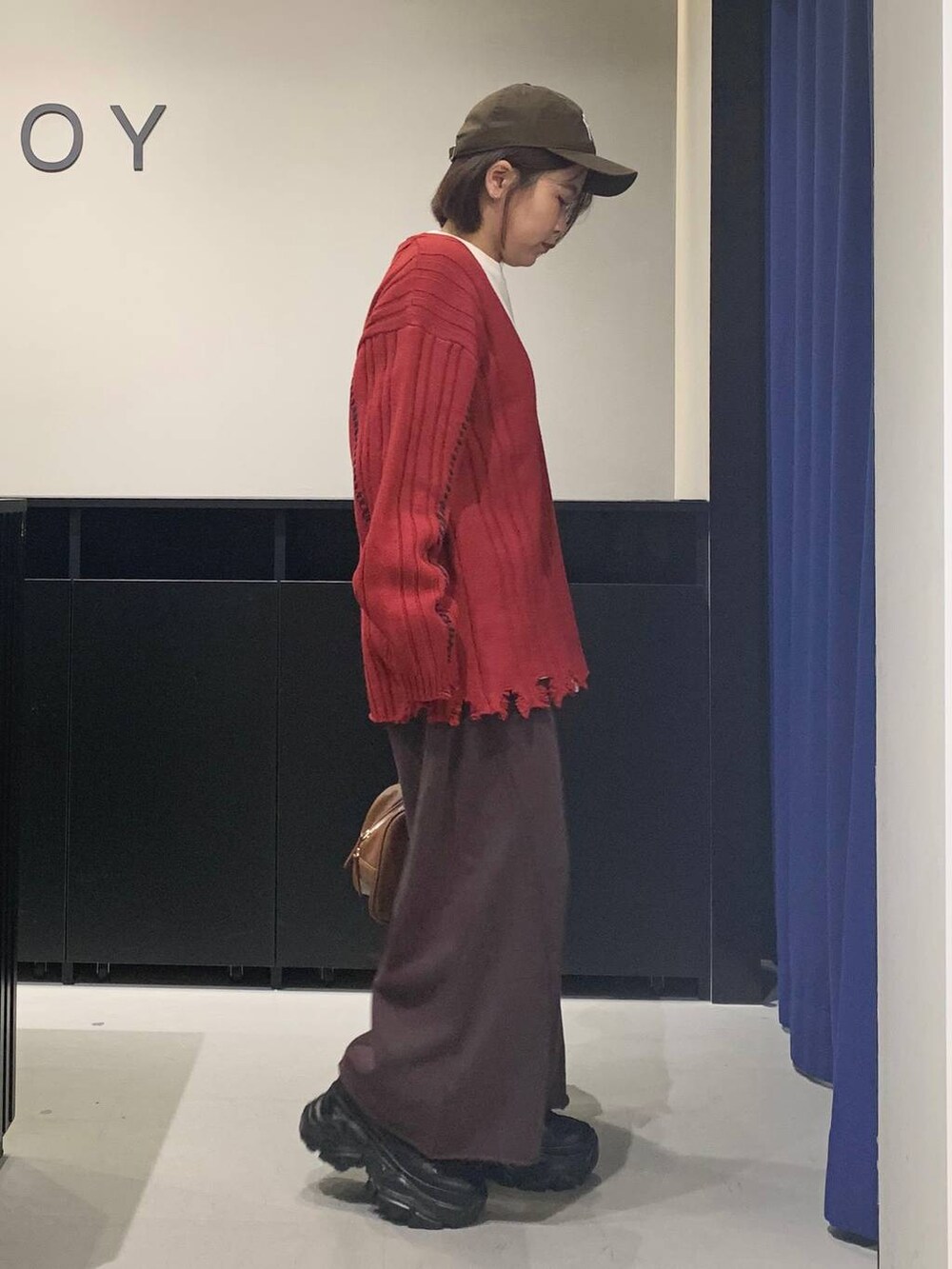 ブラック系のブーツ、ブラウン系のスウェットパンツ、イエロー系のボストンバッグを着用したレディースの秋コーディネートの4枚目の写真