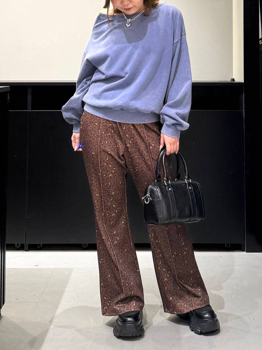 ブラック系のブーツ、ブラック系のボストンバッグ、その他のその他パンツを着用したレディースの冬コーディネートの2枚目の写真