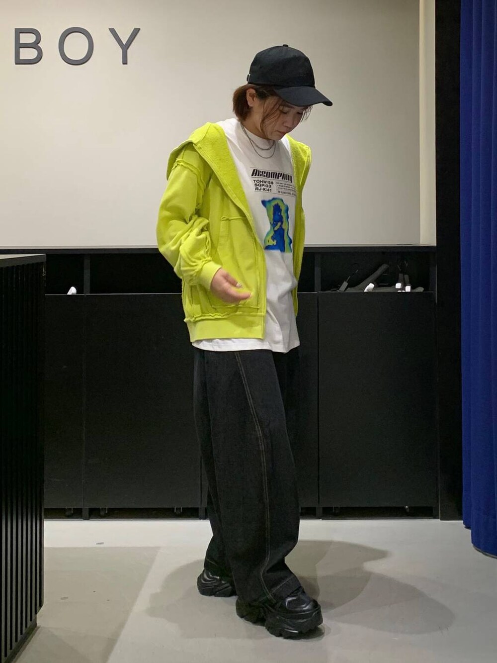 ブラック系のスニーカー、ブラック系のデニムパンツ、ホワイト系のTシャツ/カットソーを着用したレディースの秋コーディネートの3枚目の写真