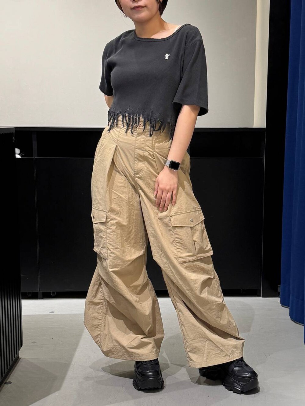 ブラック系のスニーカー、ブラック系のTシャツ/カットソー、ベージュ系のカーゴパンツを着用したレディースの夏コーディネートの2枚目の写真