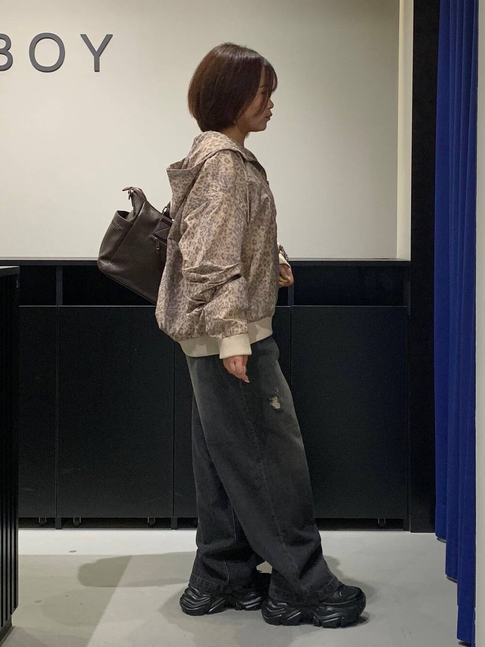 ブラック系のスニーカー、ブラウン系のボストンバッグ、その他のブルゾンを着用したレディースの秋コーディネートの4枚目の写真