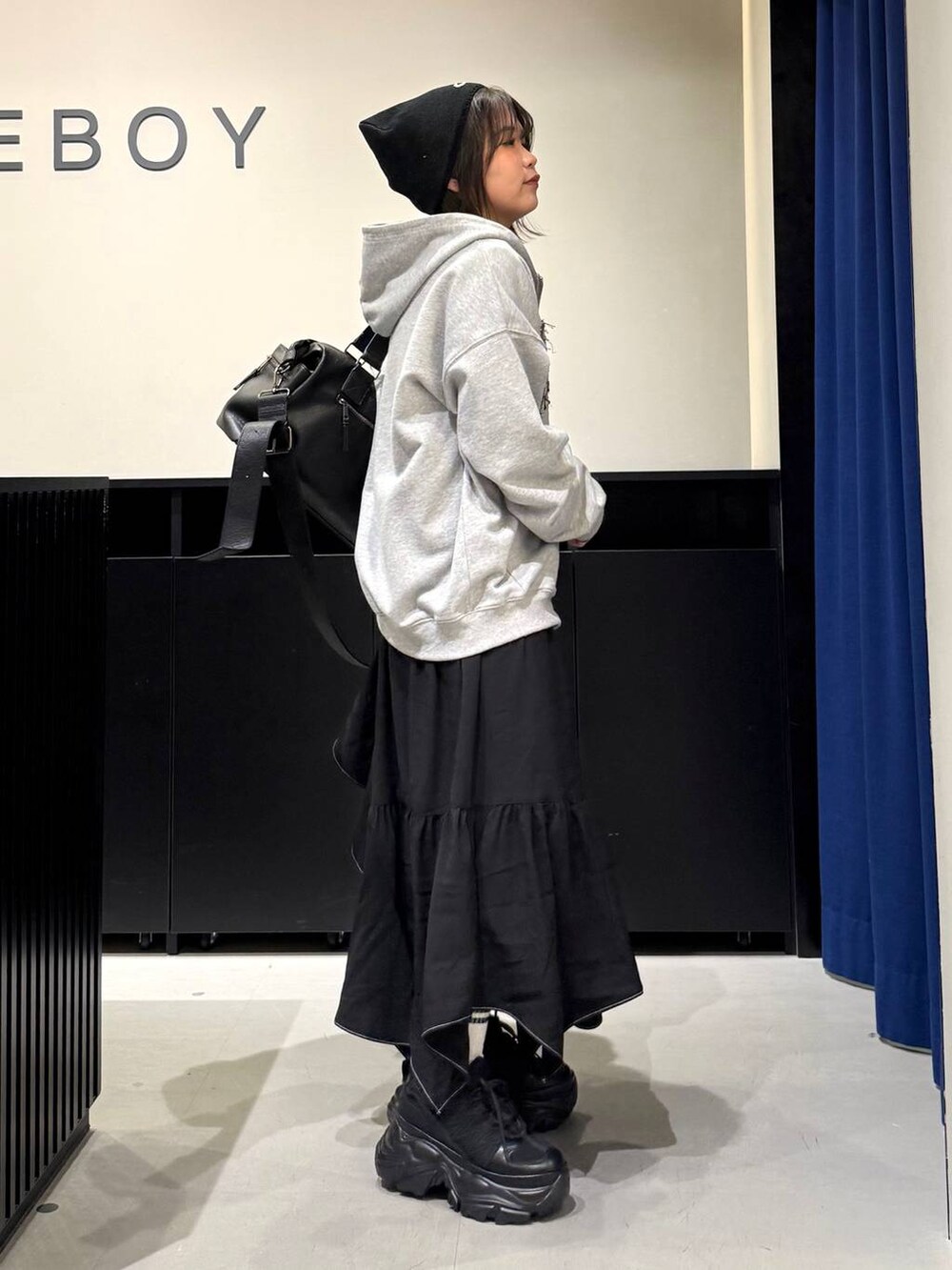 ブラック系のスニーカー、ブラック系のボストンバッグ、ブラック系のスカートを着用したレディースの冬コーディネートの4枚目の写真