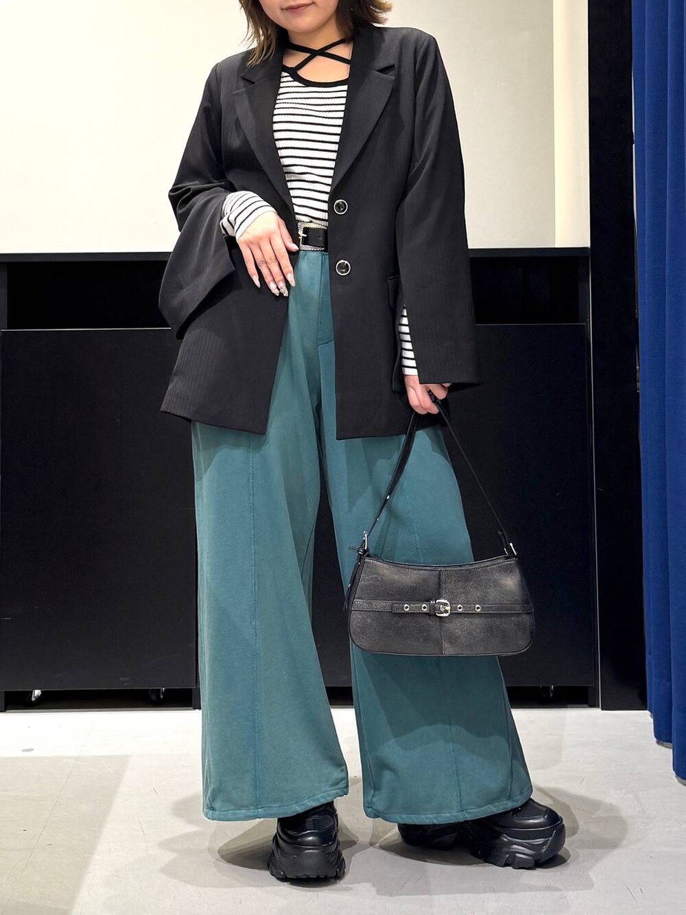 ブラック系のスニーカー、ホワイト系のニット/セーター、ブラック系のテーラードジャケットを着用したレディースの冬コーディネートの2枚目の写真