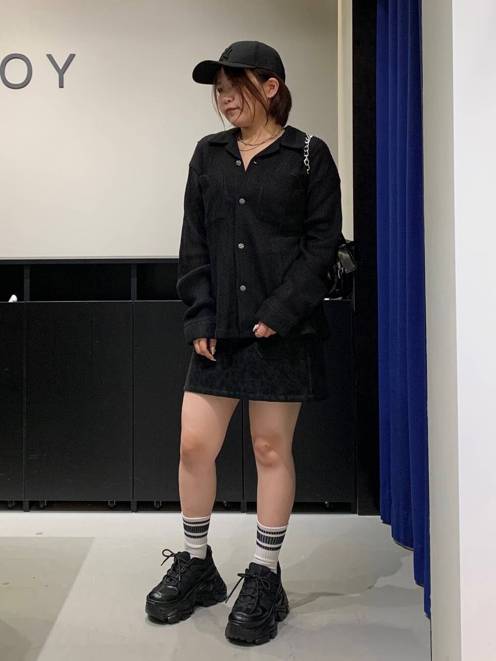 ブラック系のスニーカー、ブラック系のシャツ/ブラウス、ブラック系のショルダーバッグを着用したレディースの秋コーディネートの7枚目の写真