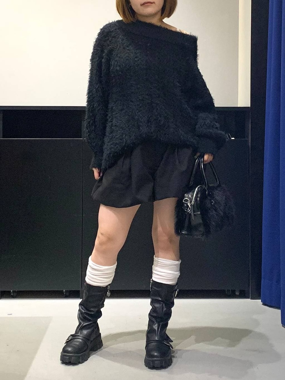 ホワイト系のキャミソール、ブラック系のワンピース、ブラック系のボストンバッグを着用したレディースの冬コーディネートの2枚目の写真