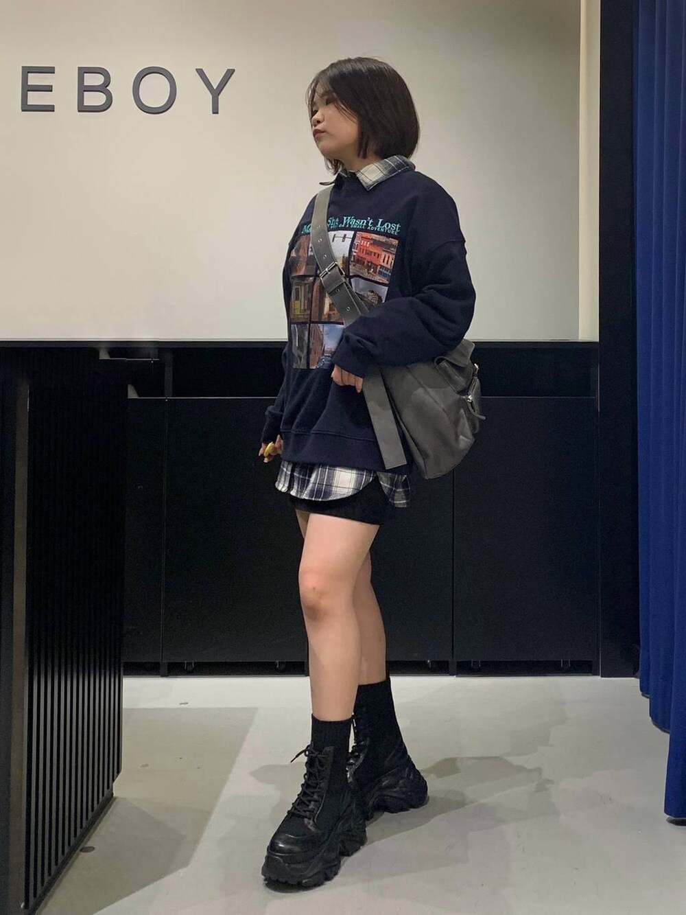 ブラック系のブーツ、グレー系のショルダーバッグ、ブラック系のスカートを着用したレディースの秋コーディネートの7枚目の写真