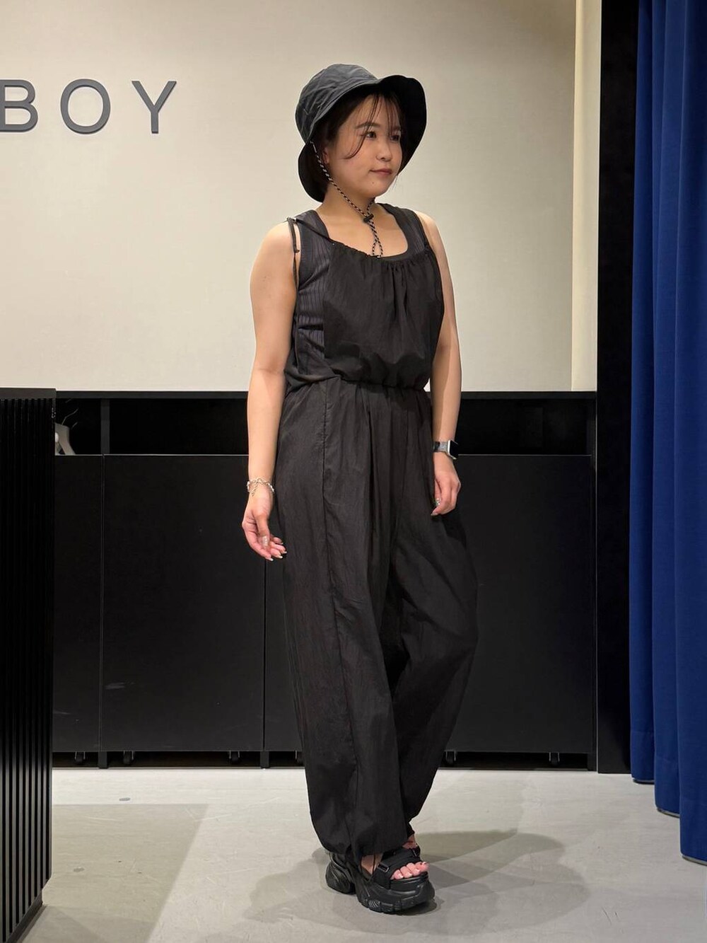 ブラック系のサンダル、グレー系のタンクトップ、ブルー系のサロペット/オーバーオールを着用したレディースの夏コーディネートの3枚目の写真