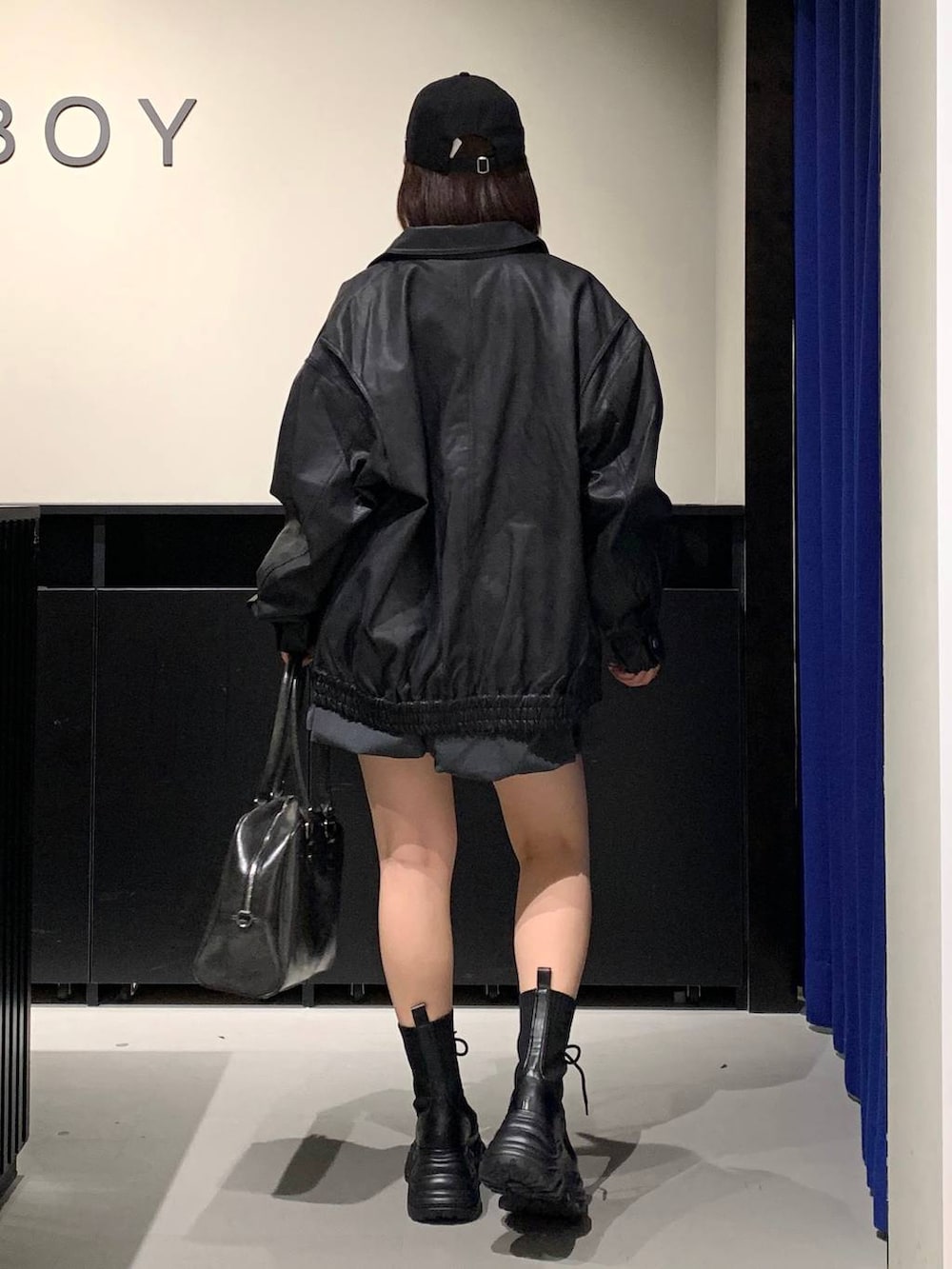 ブラック系のブーツ、ブラック系のボストンバッグ、ブラック系のブルゾンを着用したレディースの冬コーディネートの5枚目の写真