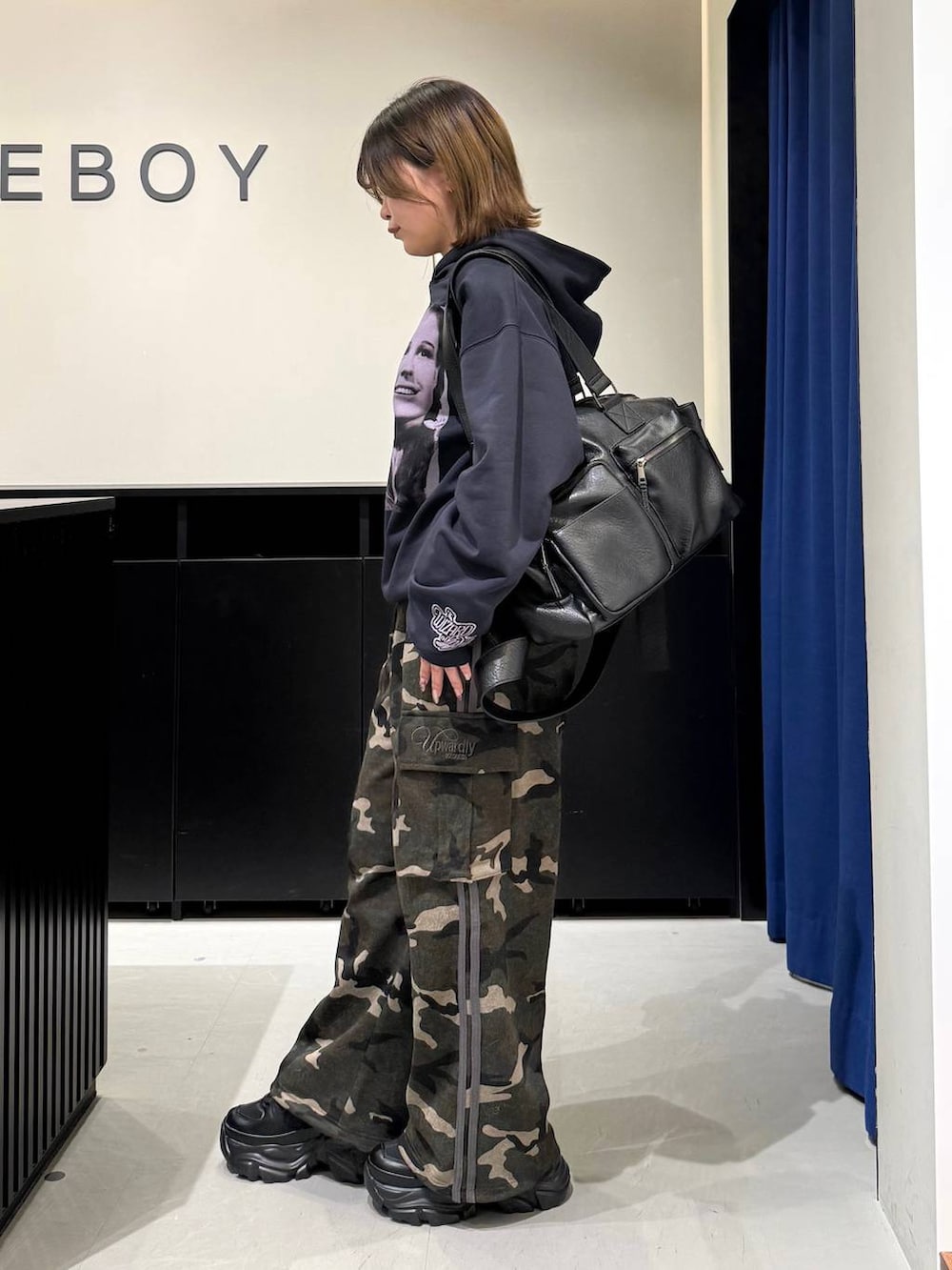 ブラック系のスニーカー、ブラック系のボストンバッグ、グリーン系のスウェットパンツを着用したレディースの冬コーディネートの7枚目の写真