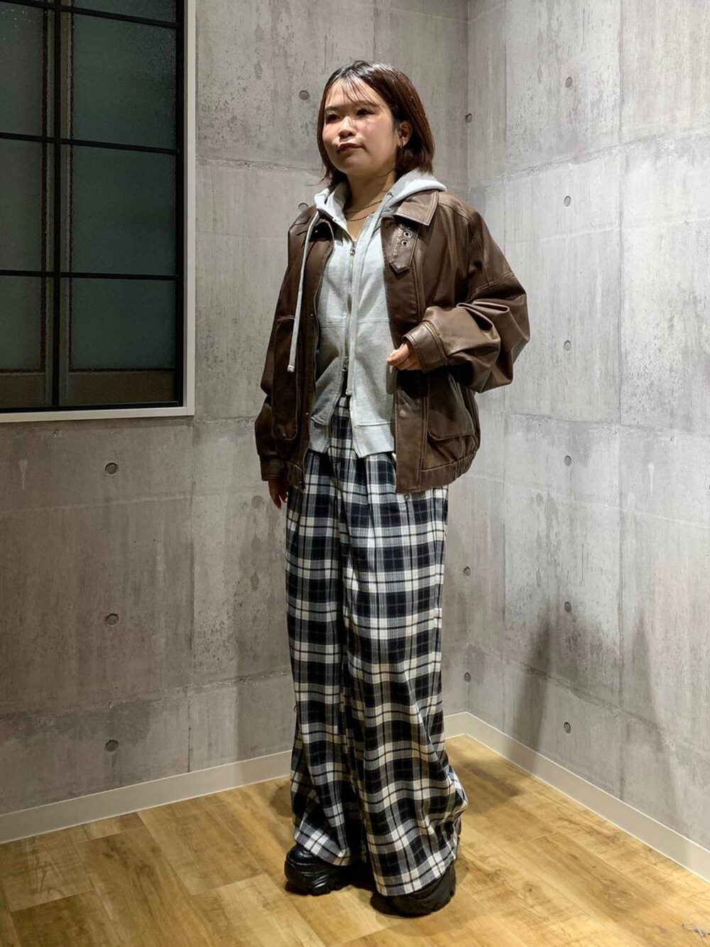 ブラック系のスニーカー、ブラウン系のブルゾン、グレー系のパーカーを着用したレディースの秋コーディネートの7枚目の写真