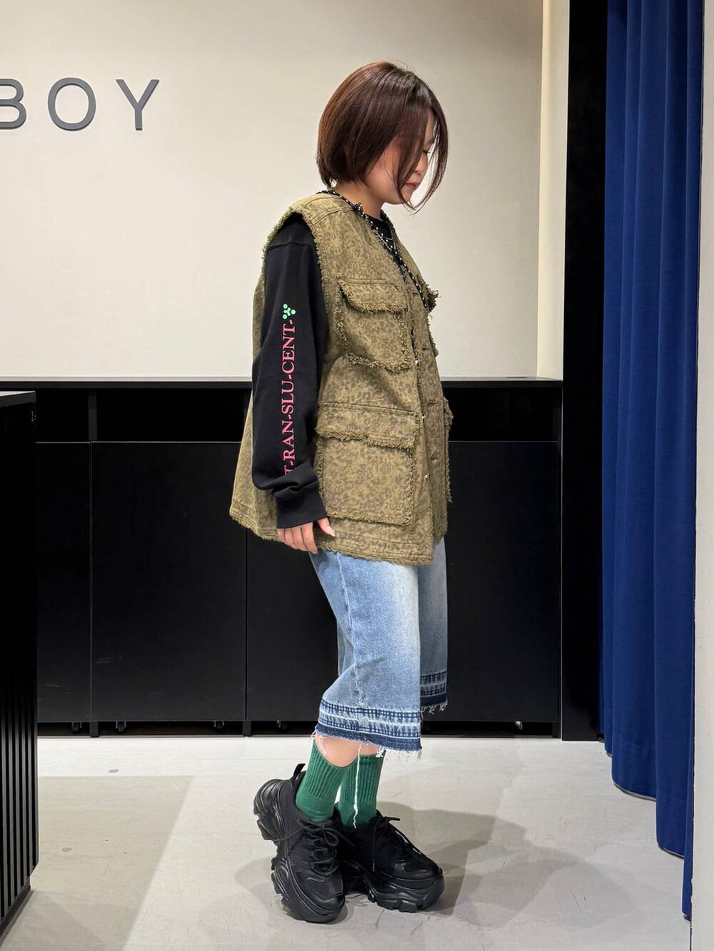 ブラック系のスニーカー、ブラック系のショルダーバッグ、ブルー系のデニムパンツを着用したレディースの夏コーディネートの3枚目の写真