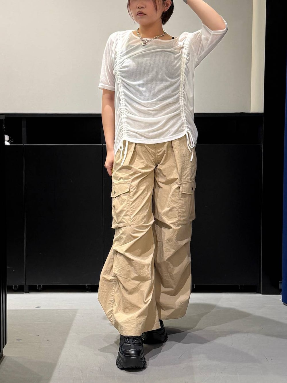 ブラック系のスニーカー、ベージュ系のカーゴパンツ、ホワイト系のTシャツ/カットソーを着用したレディースの夏コーディネートの2枚目の写真