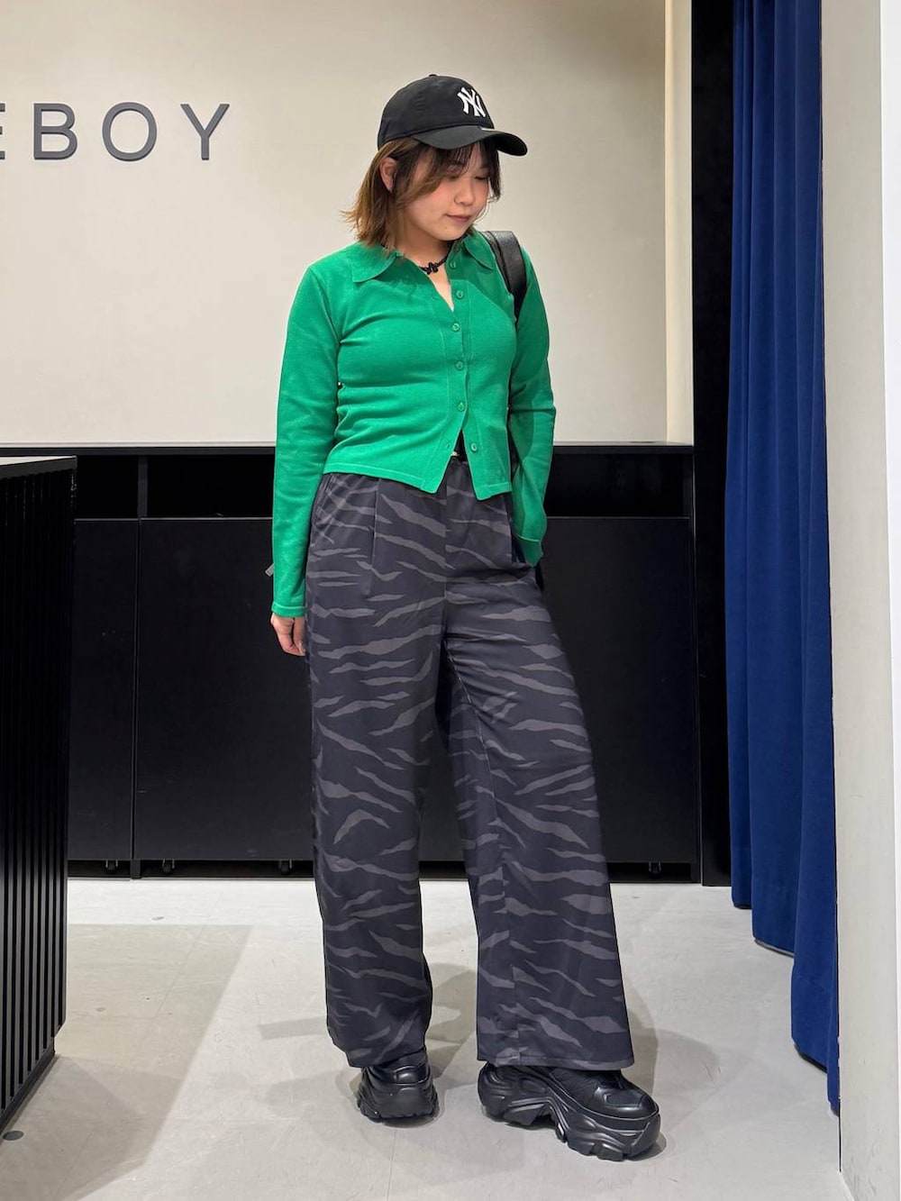 ブラック系のスニーカー、ホワイト系のキャミソール、ブラック系のボストンバッグを着用したレディースの冬コーディネートの3枚目の写真