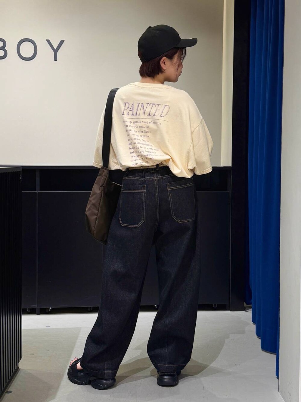 ブラック系のサンダル、ベージュ系のTシャツ/カットソー、ブラック系のデニムパンツを着用したレディースの夏コーディネートの5枚目の写真