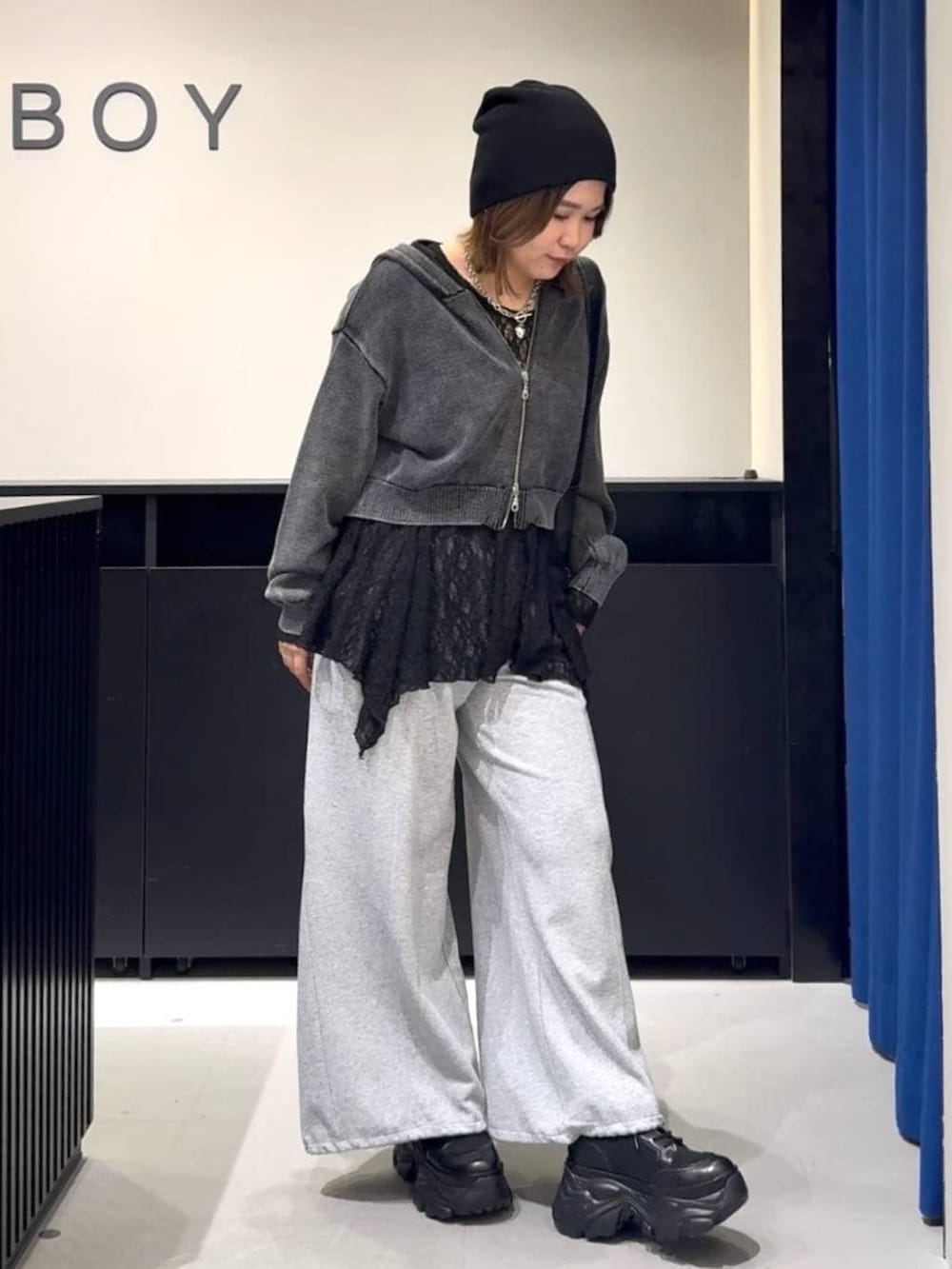 ブラック系のブーツ、グレー系のパーカー、ブラック系のチュニックを着用したレディースの冬コーディネートの3枚目の写真