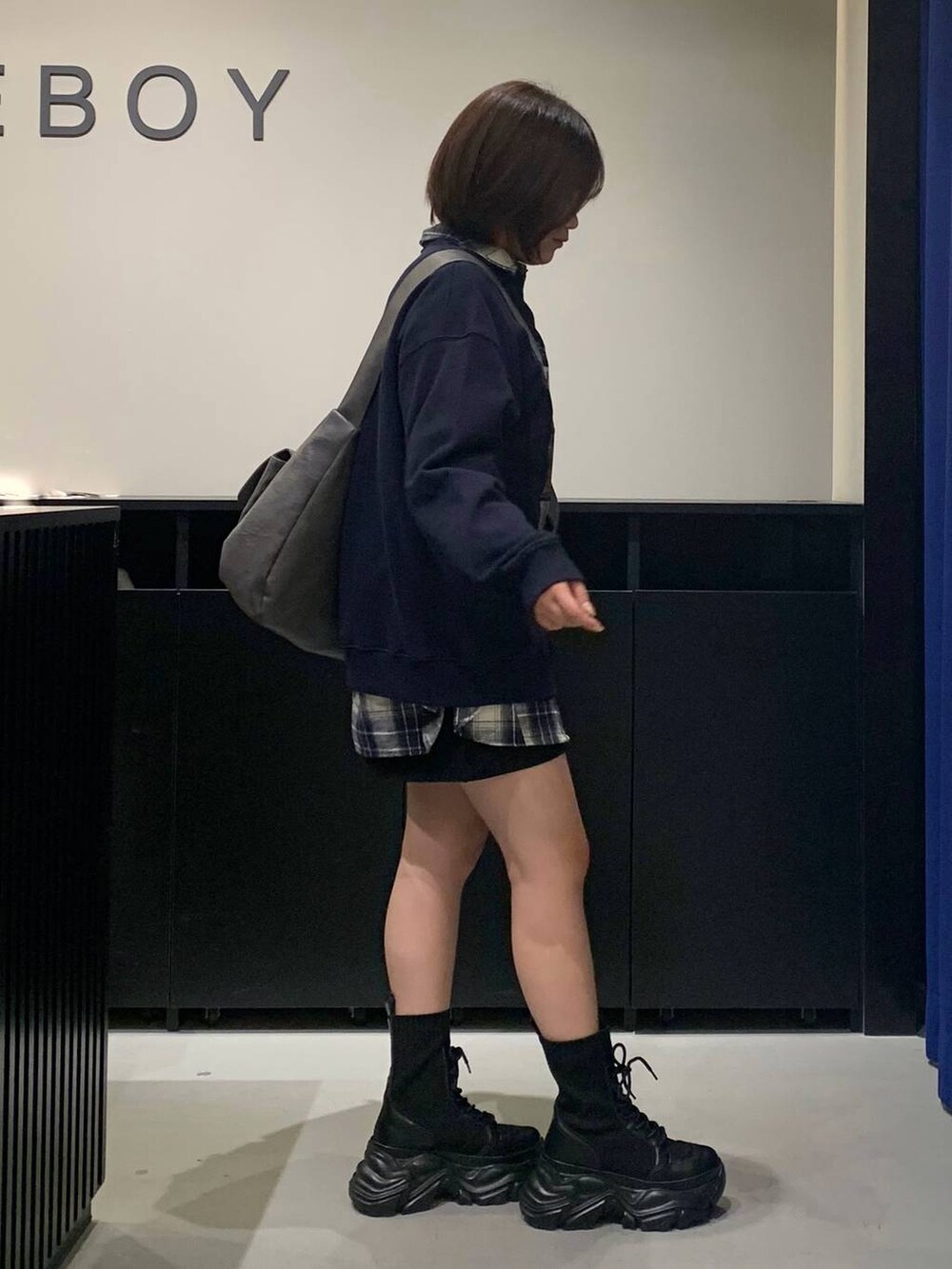 ブラック系のブーツ、グレー系のショルダーバッグ、ブラック系のスカートを着用したレディースの秋コーディネートの4枚目の写真