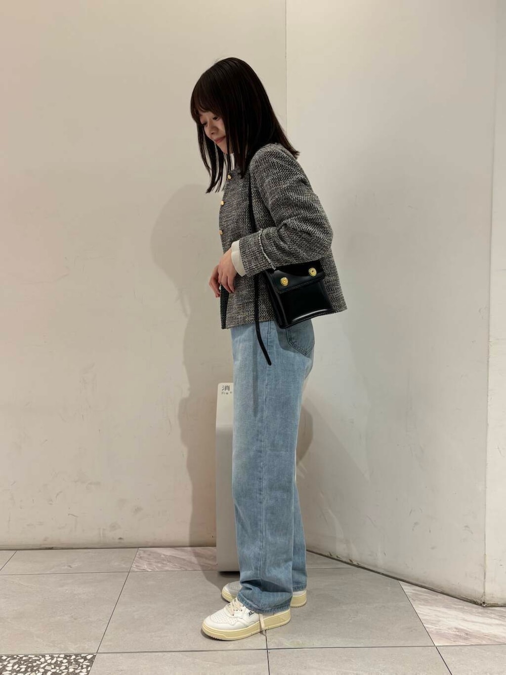 ブラック系のノーカラージャケット、グレー系のニット/セーター、ブラック系のショルダーバッグを着用したレディースの冬コーディネートの2枚目の写真