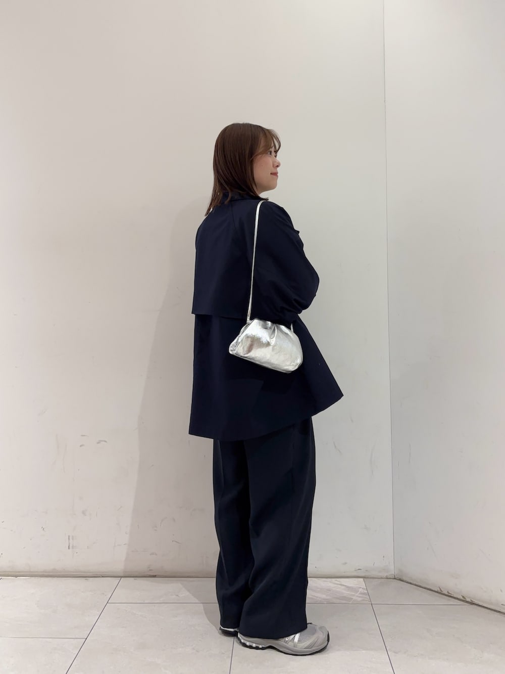 ブルー系のトレンチコート、ホワイト系のニット/セーター、ホワイト系のニット/セーターを着用したレディースの冬コーディネートの2枚目の写真