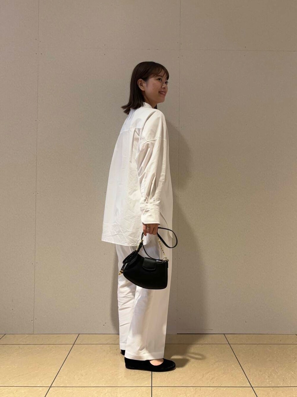 ホワイト系のその他パンツ、ホワイト系のシャツ/ブラウス、ブラック系のハンドバッグを着用したレディースの夏コーディネートの3枚目の写真