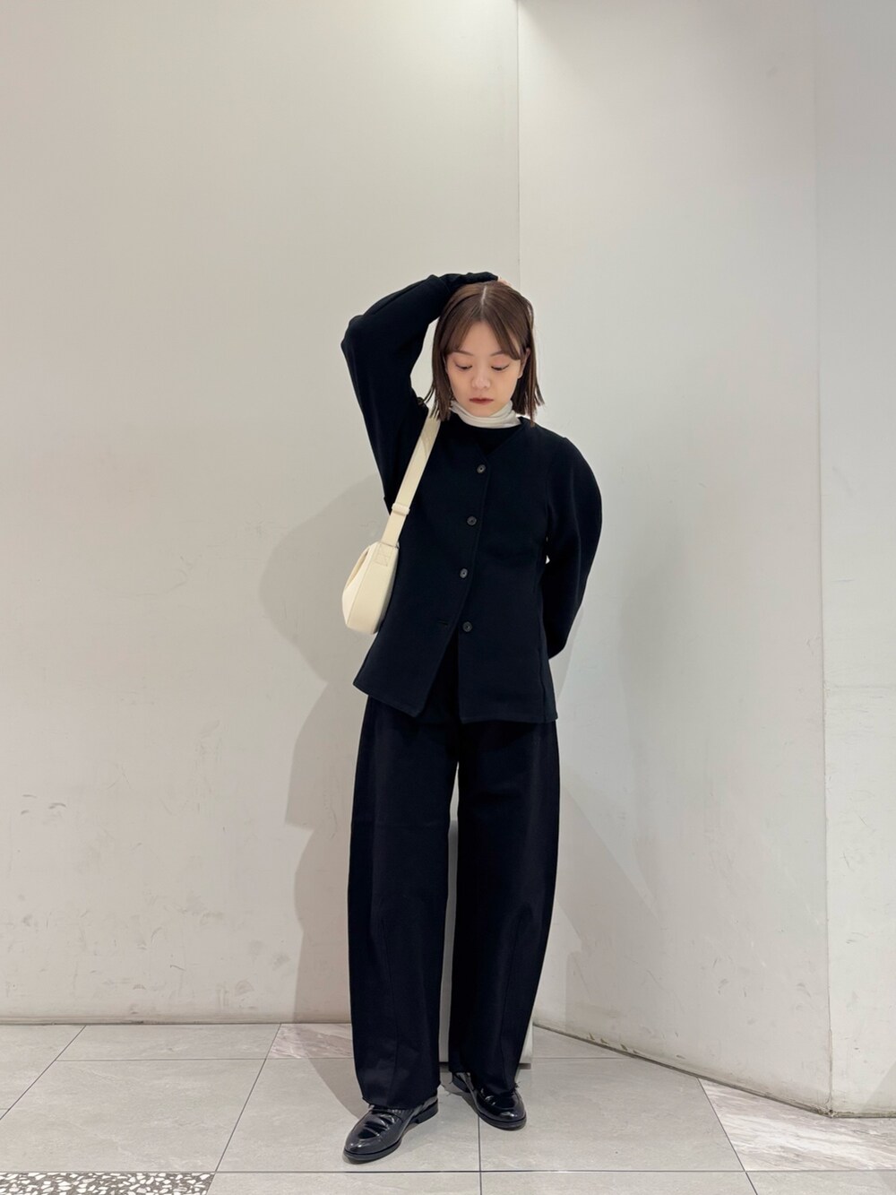 ブラック系のカーディガン/ボレロ、ブラック系のその他パンツ、ホワイト系のショルダーバッグを着用したレディースの秋コーディネートの2枚目の写真