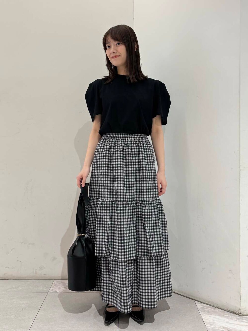 ブラック系のパンプス、その他のスカート、ブラック系のTシャツ/カットソーを着用したレディースの春コーディネートの2枚目の写真