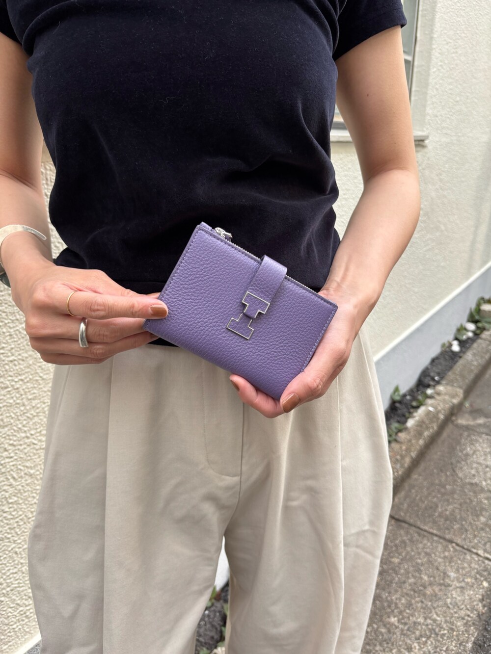 パープル系の財布を着用したレディースの春コーディネートの2枚目の写真